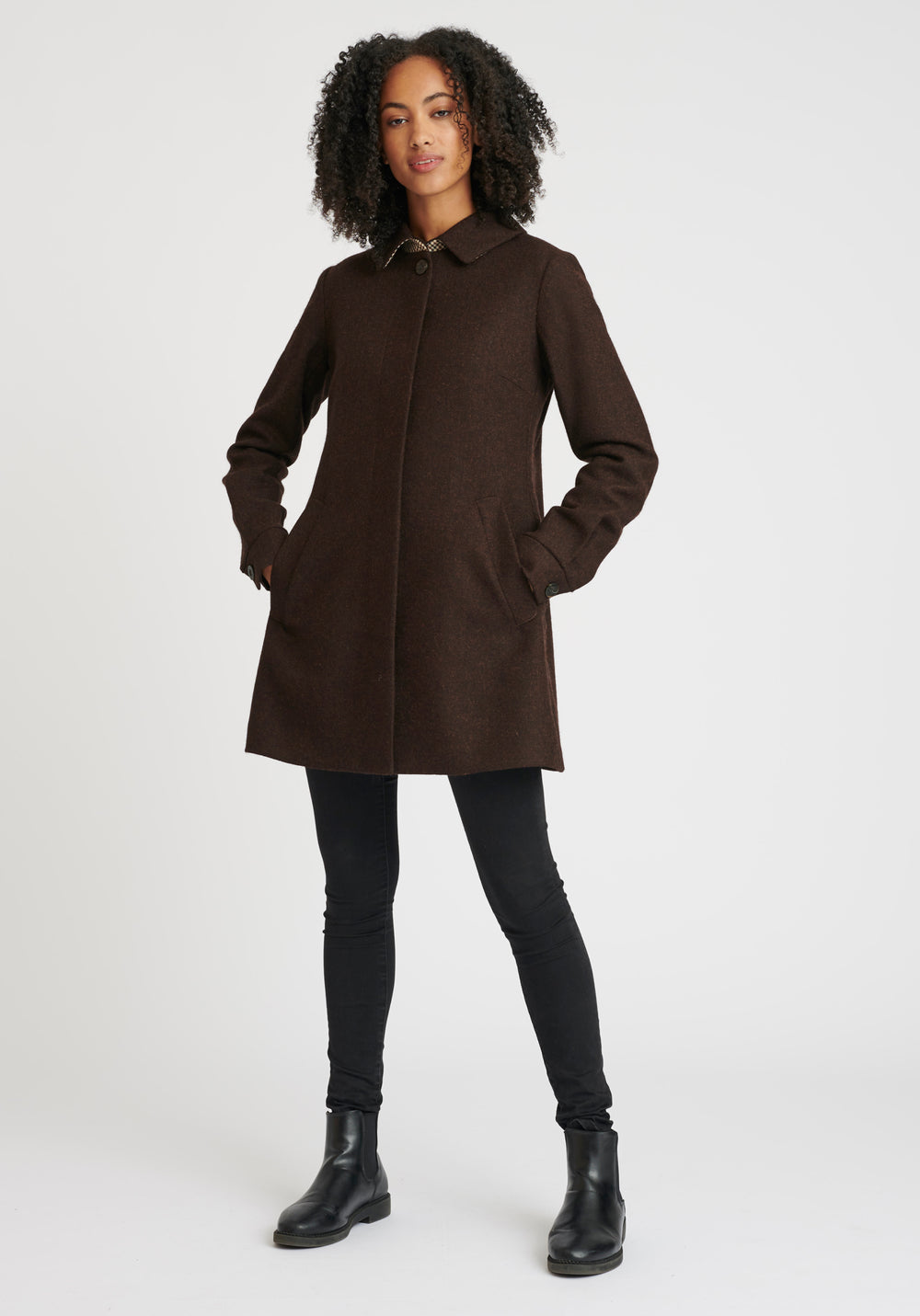 Woman wearing a brown coat on a white background