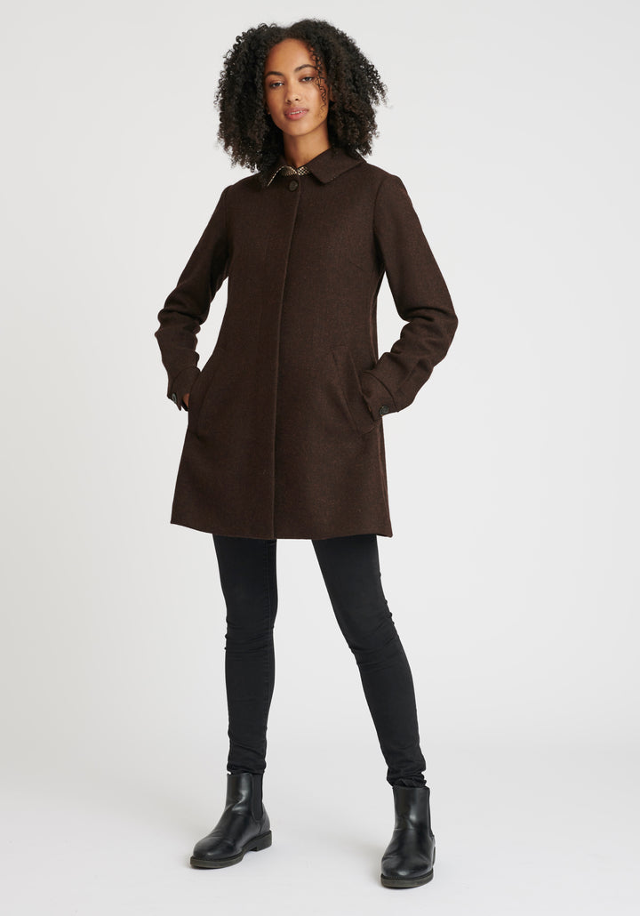 Woman wearing a brown coat on a white background
