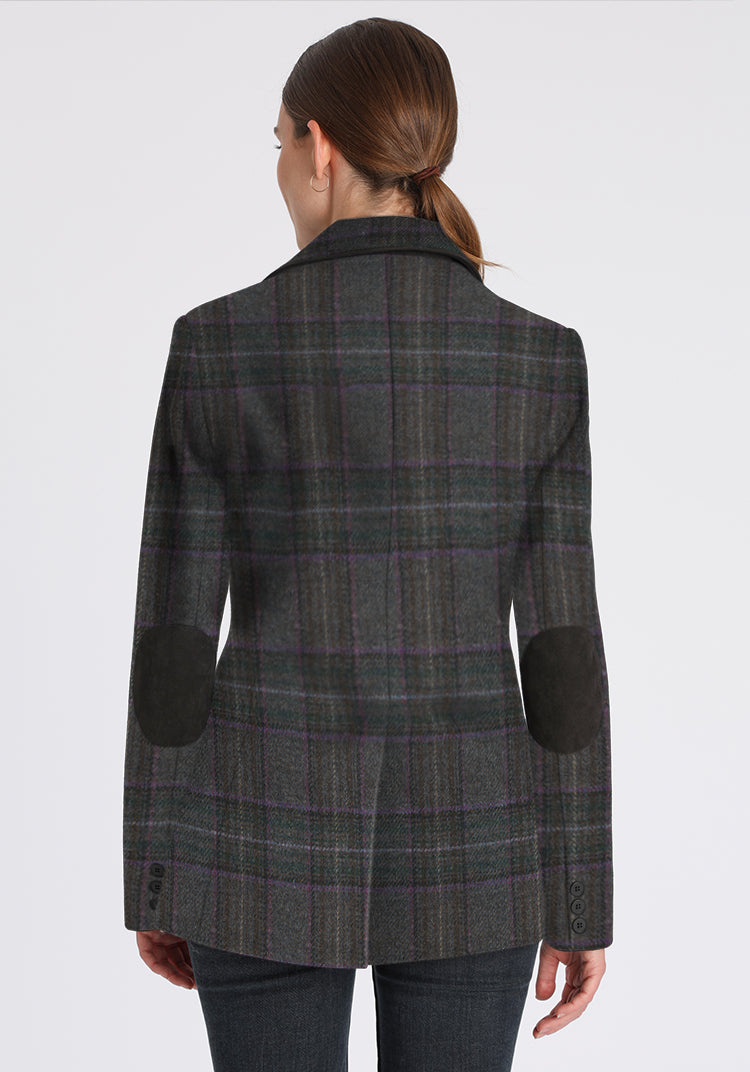 Person wearing a purple and gray plaid jacket with elbow patches on a white background