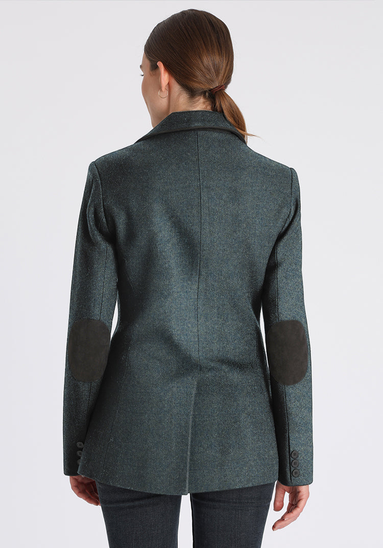 Woman wearing a teal wool jacket with grey elbow patches