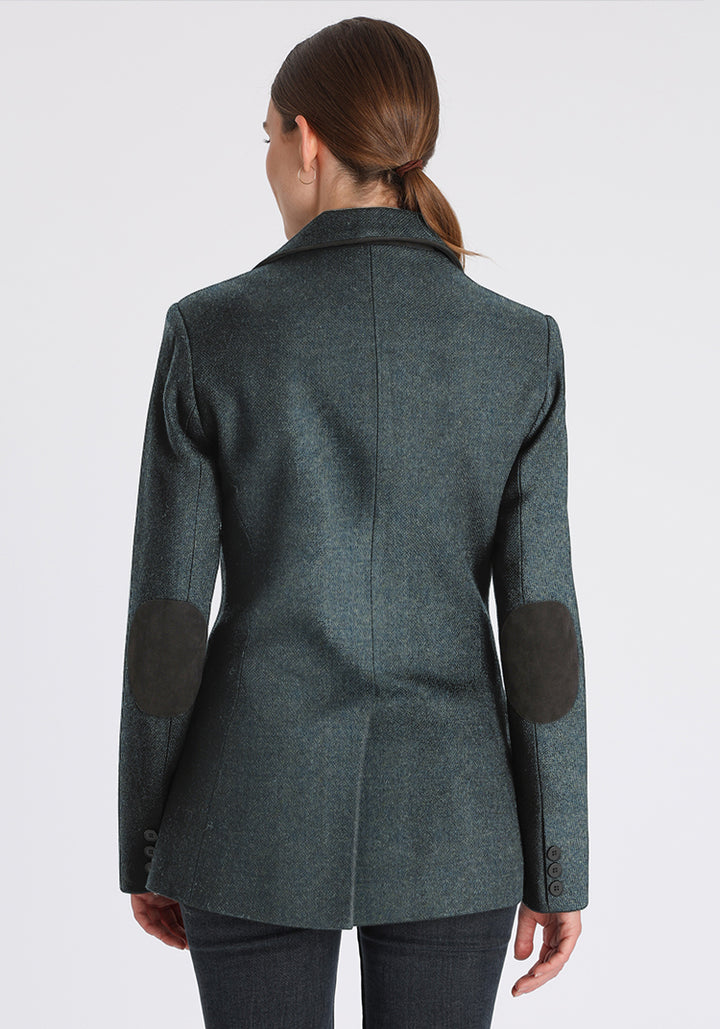 Woman wearing a teal wool jacket with grey elbow patches