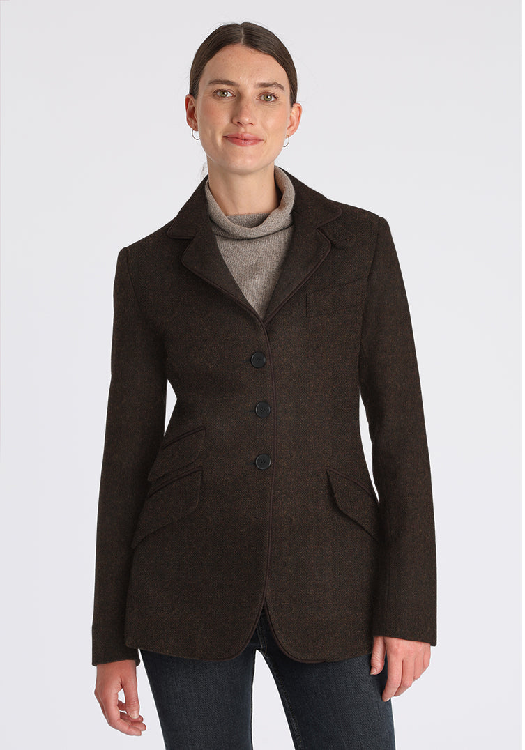 Woman wearing a brown wool jacket with black buttons up the front