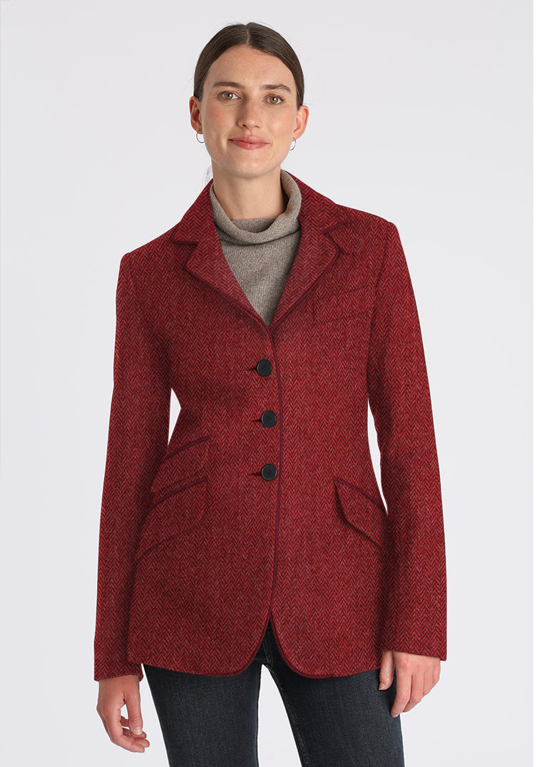 Woman wearing a red and pink herringbone wool jacket with black buttons