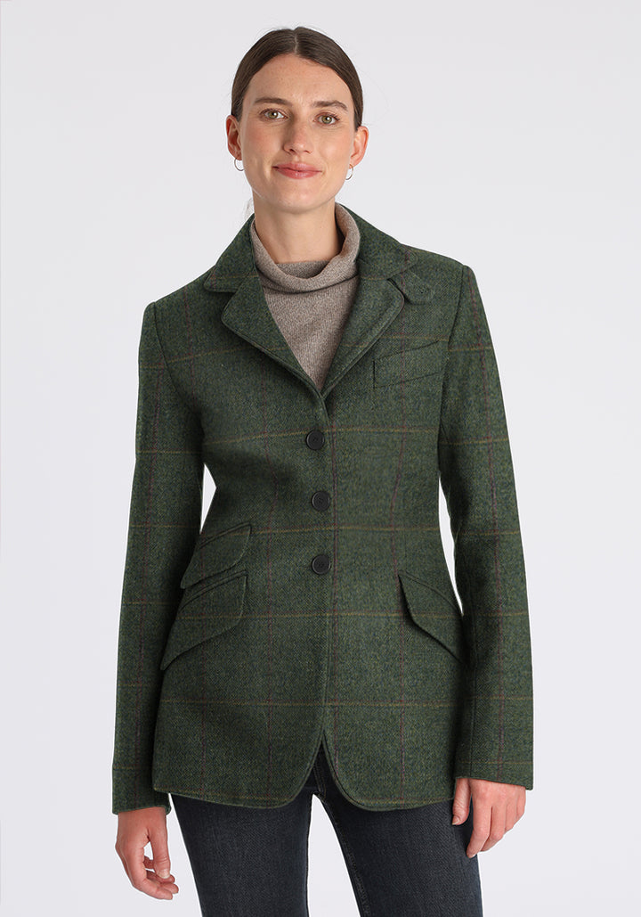 Woman wearing green wool jacket with faint yellow and red overcheck. Slate buttons down the front