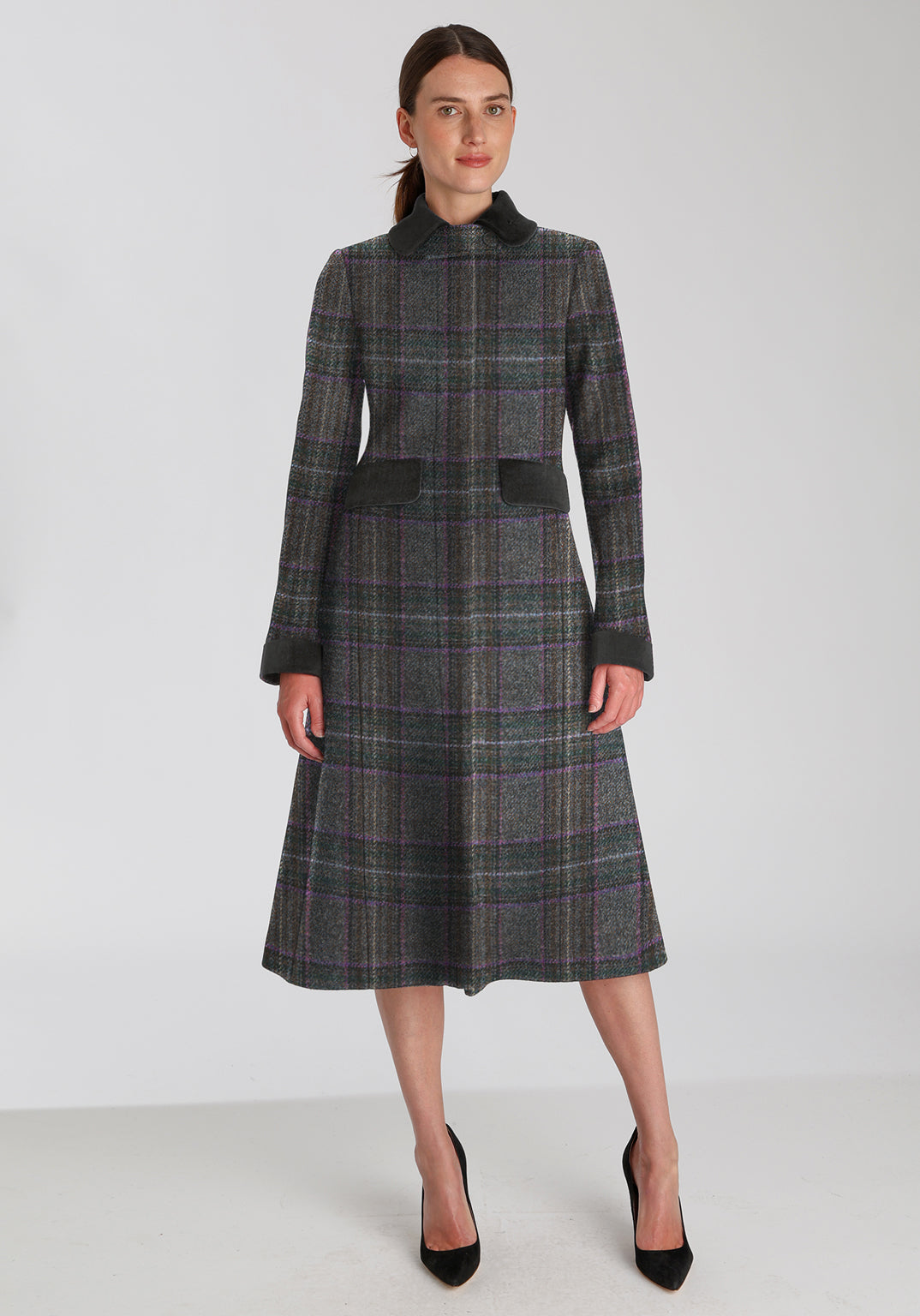 Woman wearing long purple check wool coat with contrasting dark grey pocket flaps, collar, and cuffs