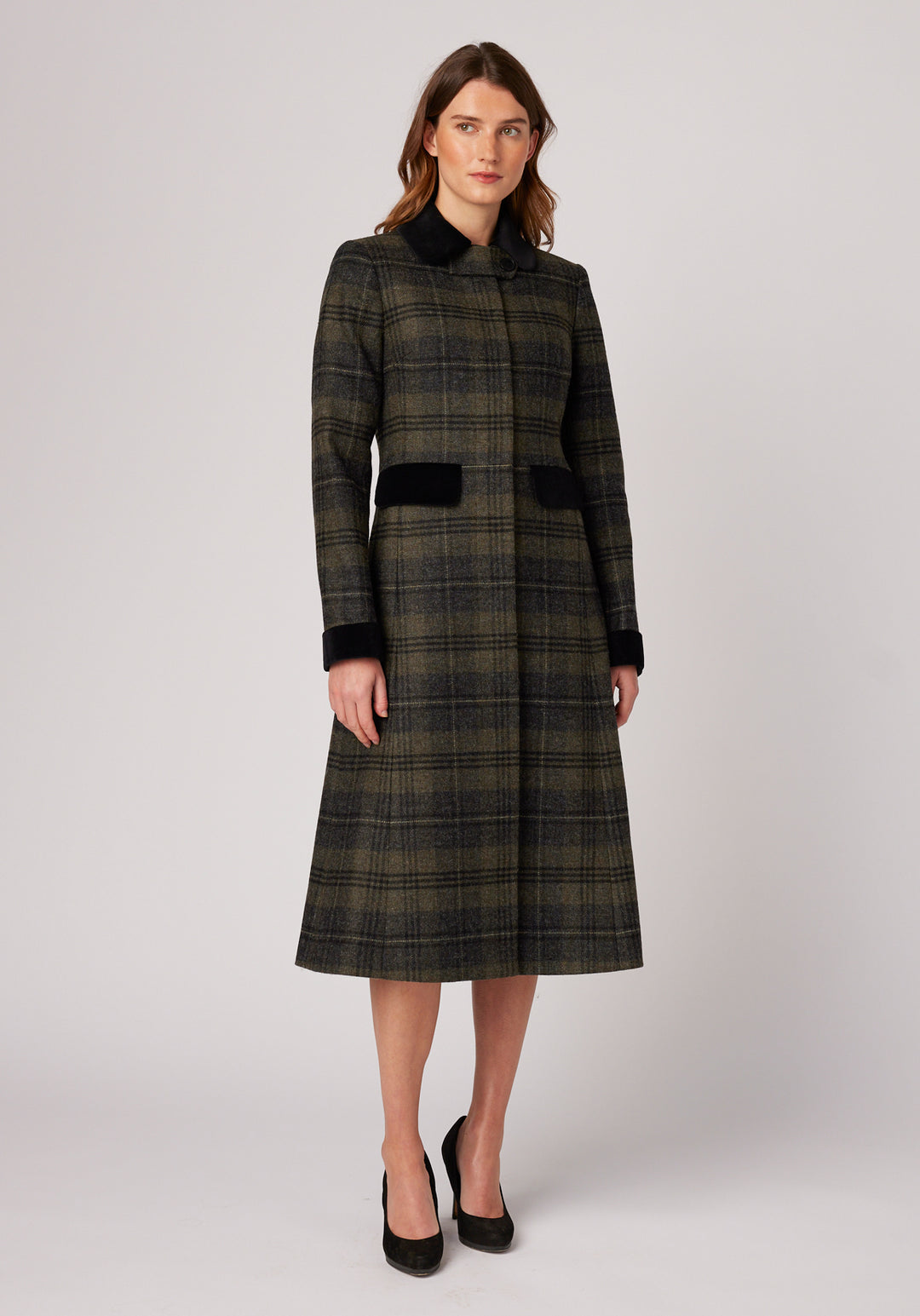Woman wearing grey and green check wool coat with black detailing on the collar , cuffs, and pocket flaps