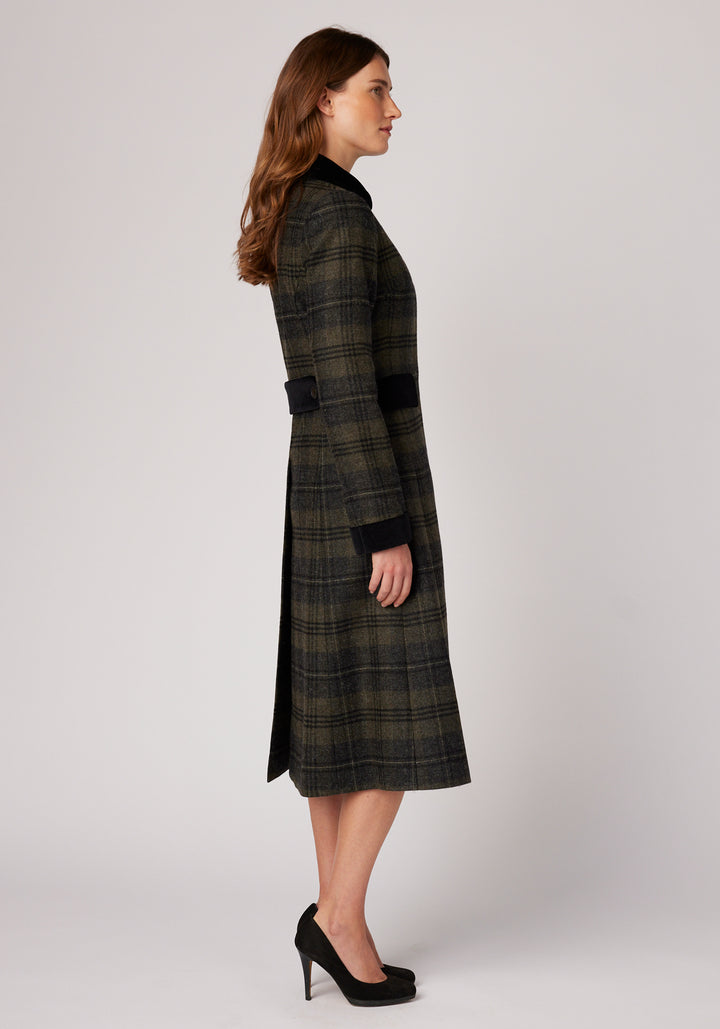 Side view of a woman wearing grey and green check wool coat with black detailing on the collar , cuffs, and pocket flaps