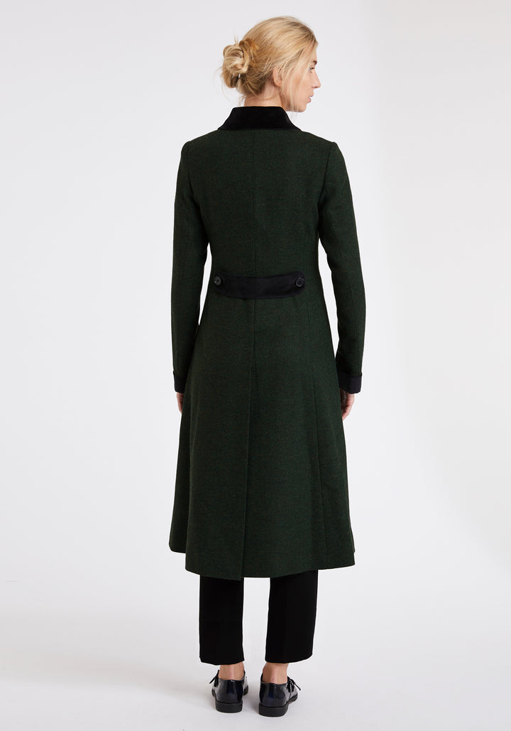 Back of woman wearing a green wool coat with black detailing on the collar and back belt