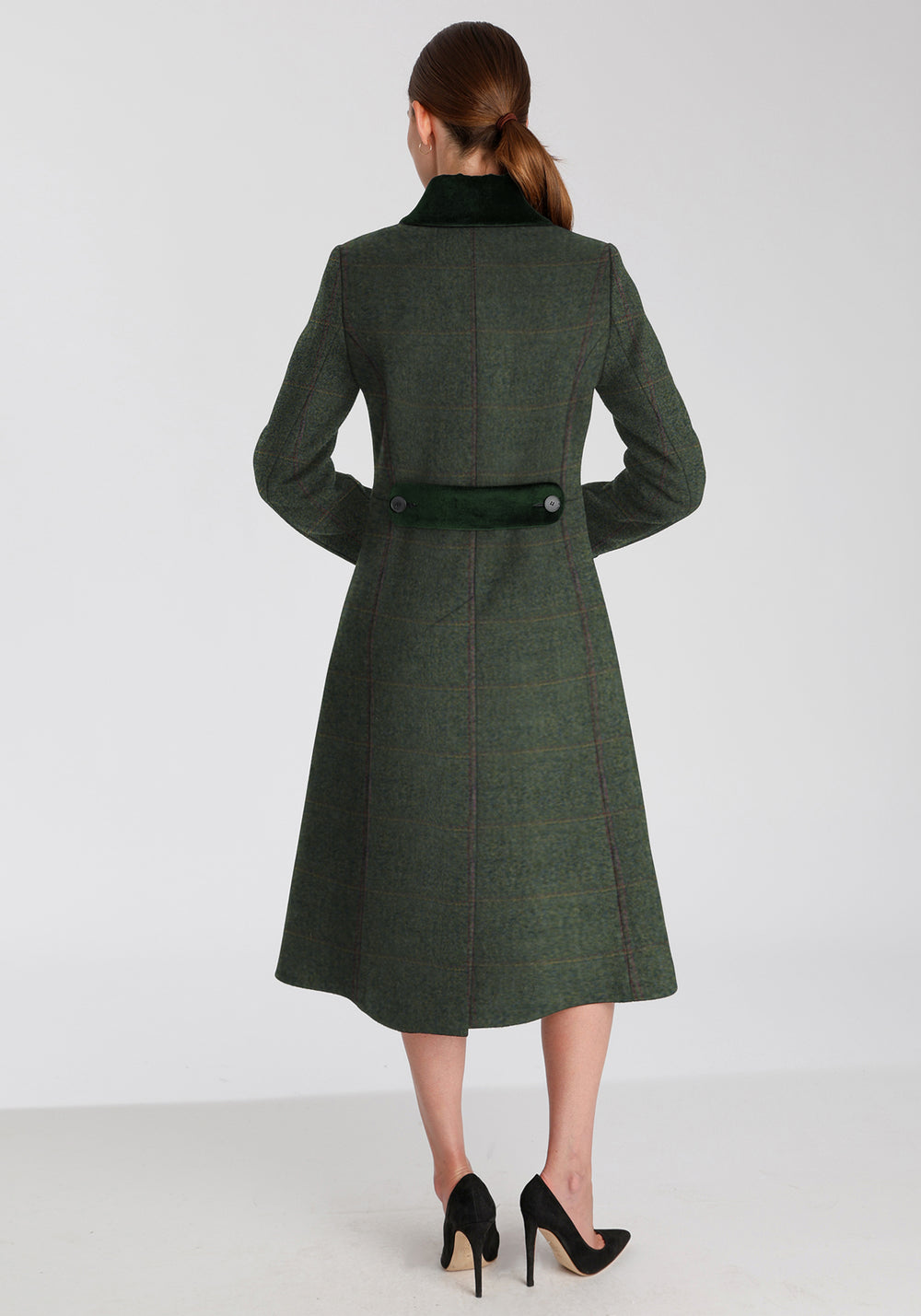 Back of woman wearing sage green wool coat with a faint yellow and red overcheck. Dark green detailing on the collar and back belt