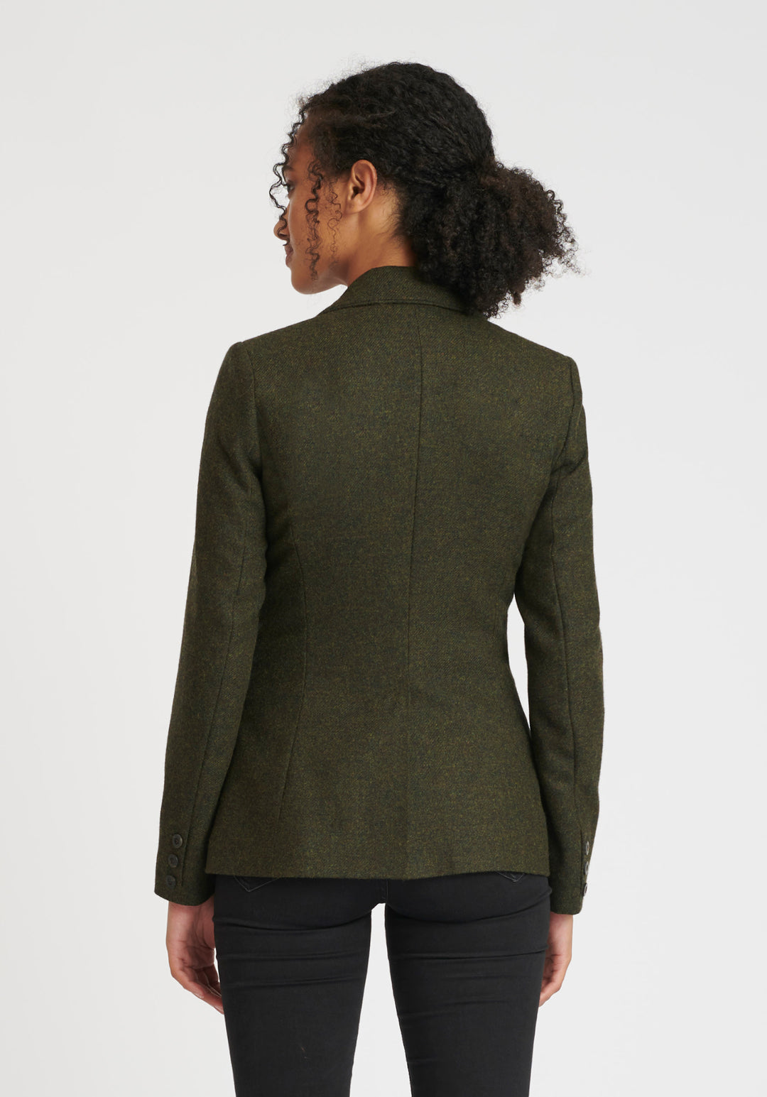 Back of woman wearing a green wool jacket with chocolate brown buttons