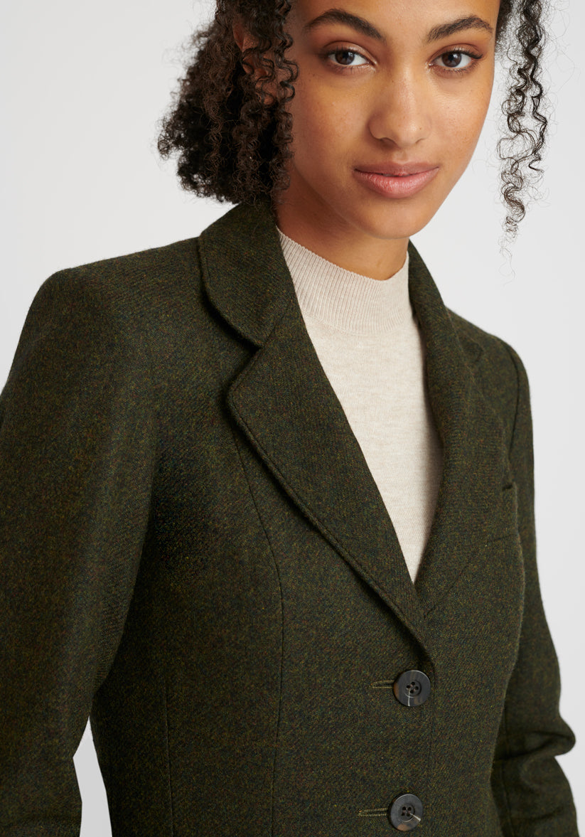 Woman wearing a green wool jacket with chocolate brown buttons