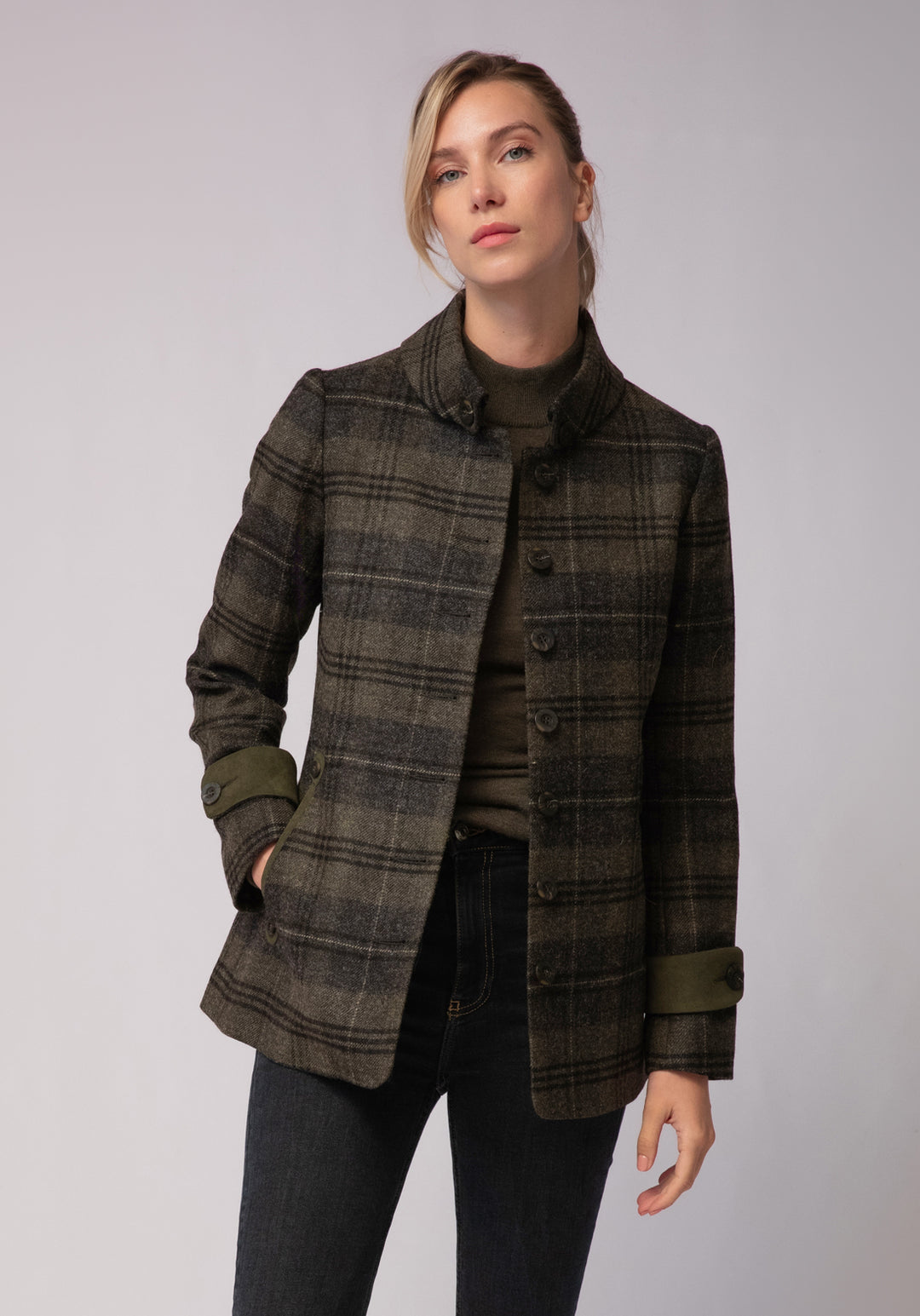 Woman wearing grey and green check wool jacket with buttons and moss green cuff detail
