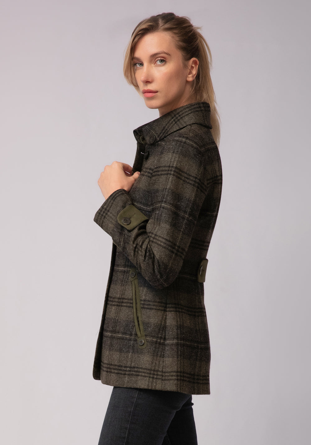 Woman wearing grey and green check wool jacket with buttons and moss green pocket trim and cuff detail