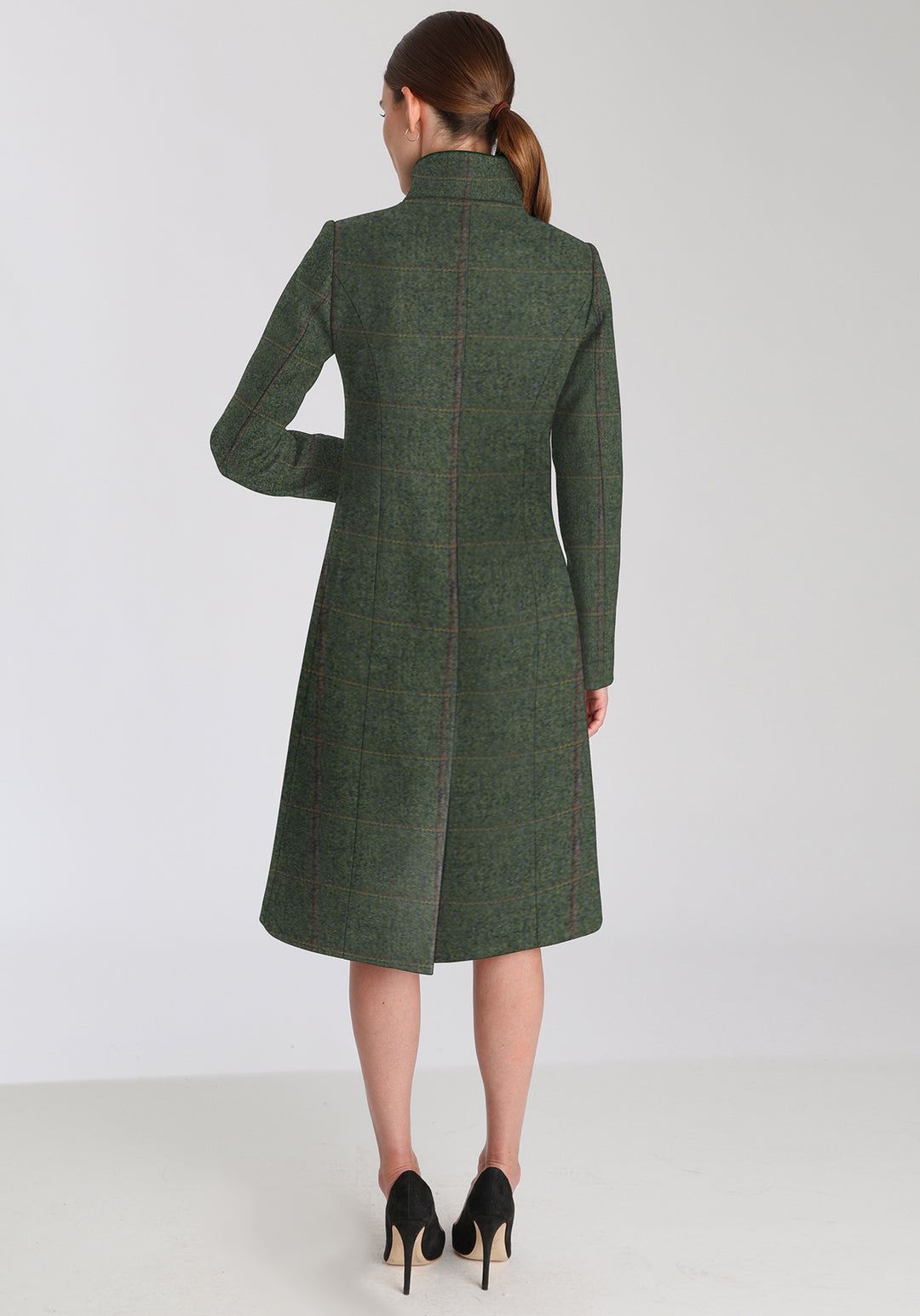 Back of a woman wearing a green coat on a white background