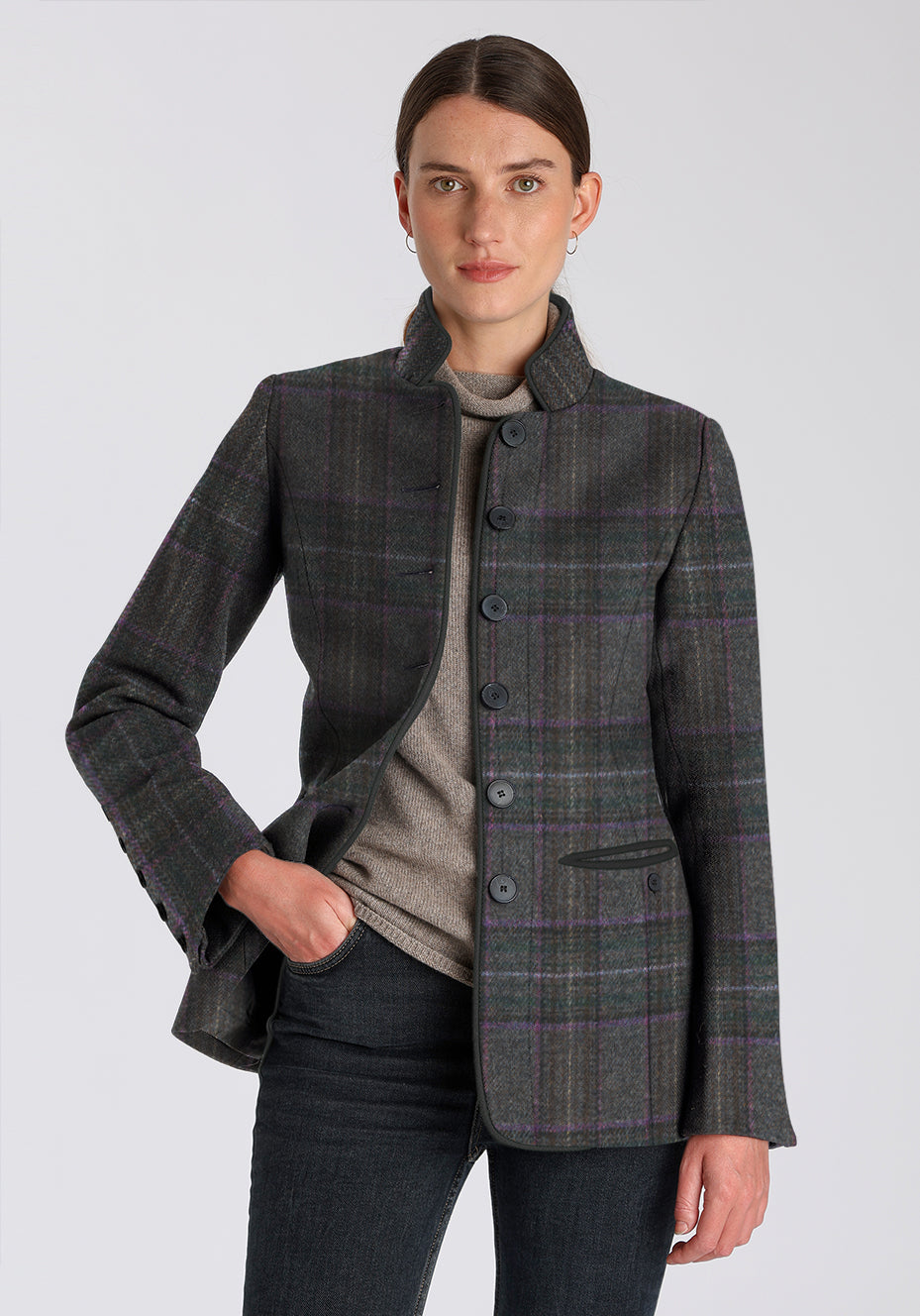 Woman wearing a purple checkered coat with black buttons down the front on a white background