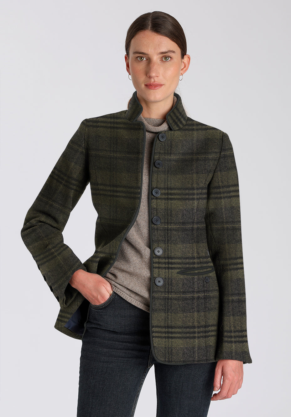 Woman wearing a green check jacket with black buttons down the front on a plain background