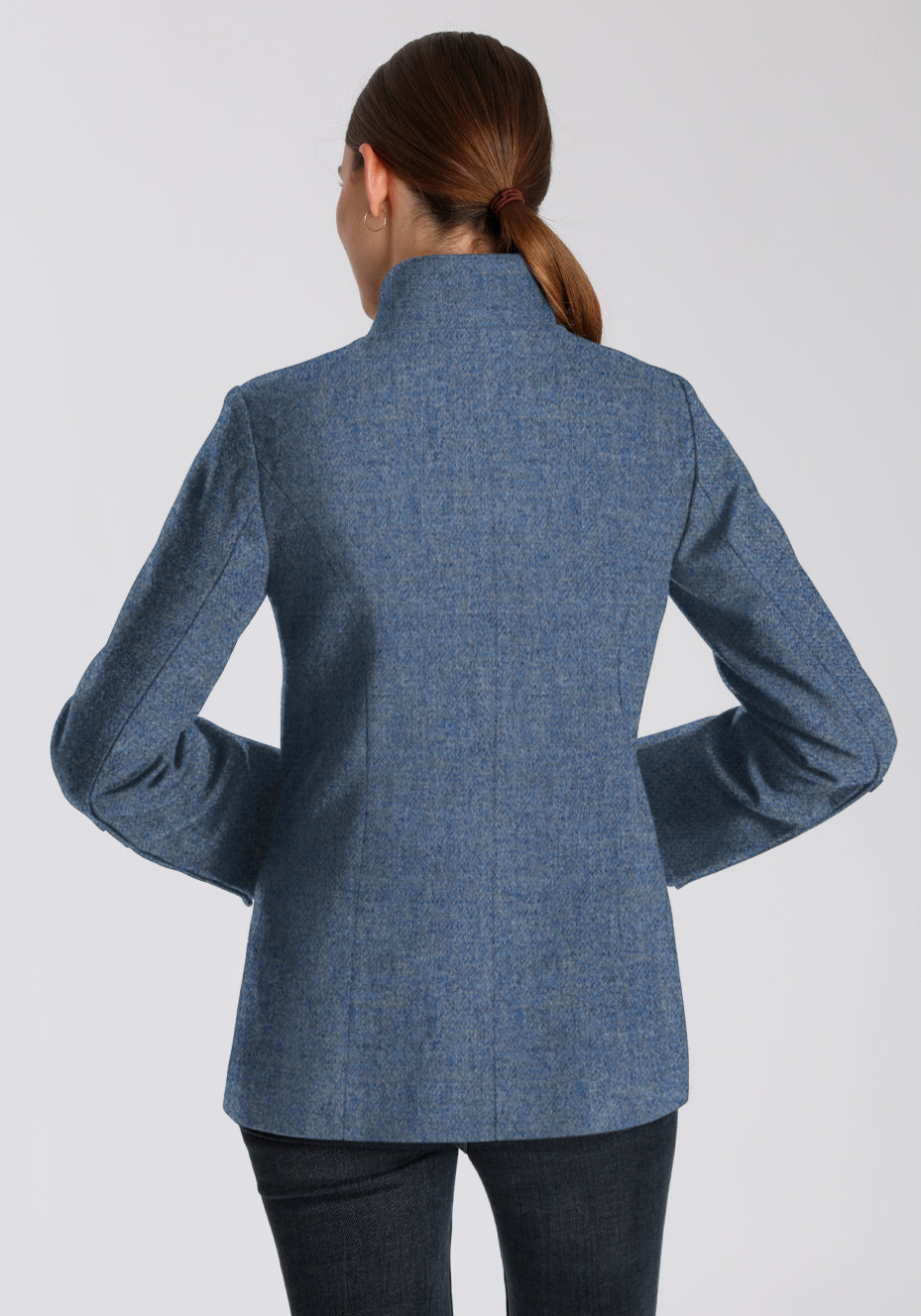 Back of a woman wearing a blue jacket on a white background