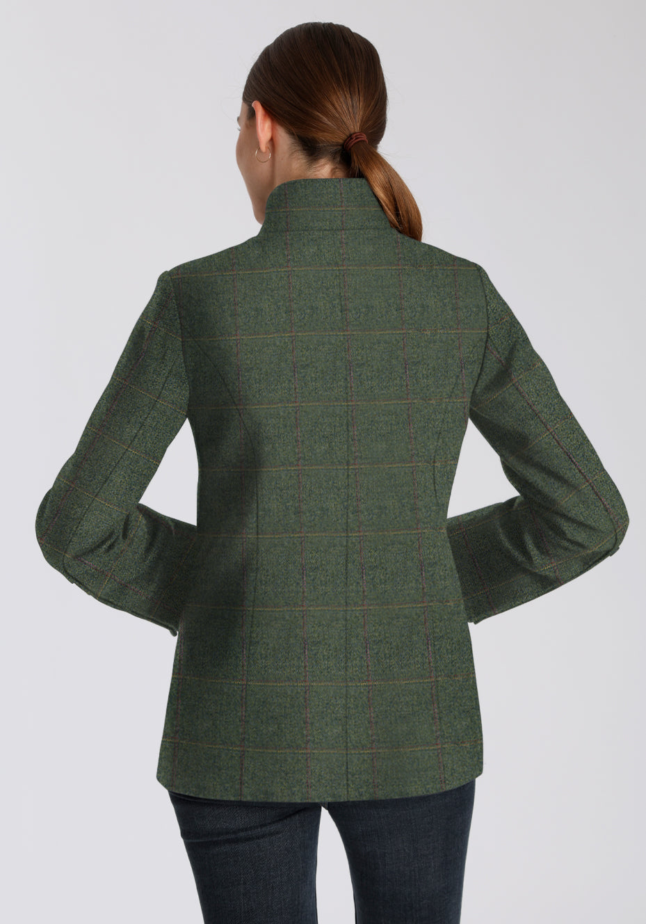 Back of woman wearing a green wool jacket with a yellow and red check on a plain background