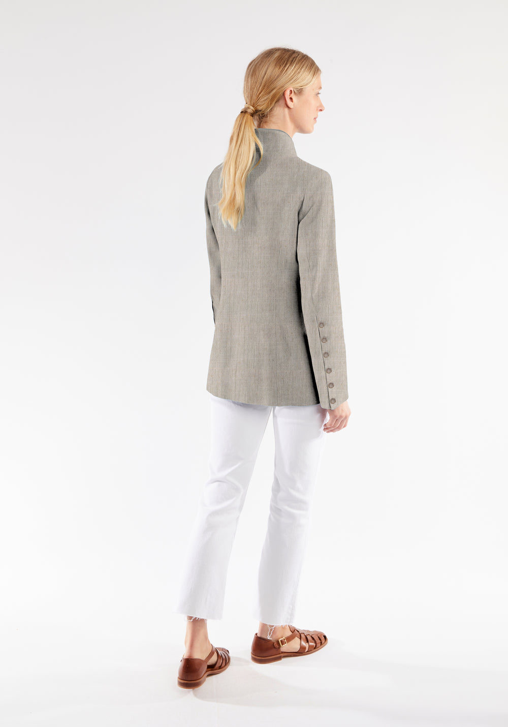 Model wearing the Patmos jacket in Chinchilla linen blend, a slim-fit style featuring a mandarin collar, front pockets, and generous sleeves with button detailing.