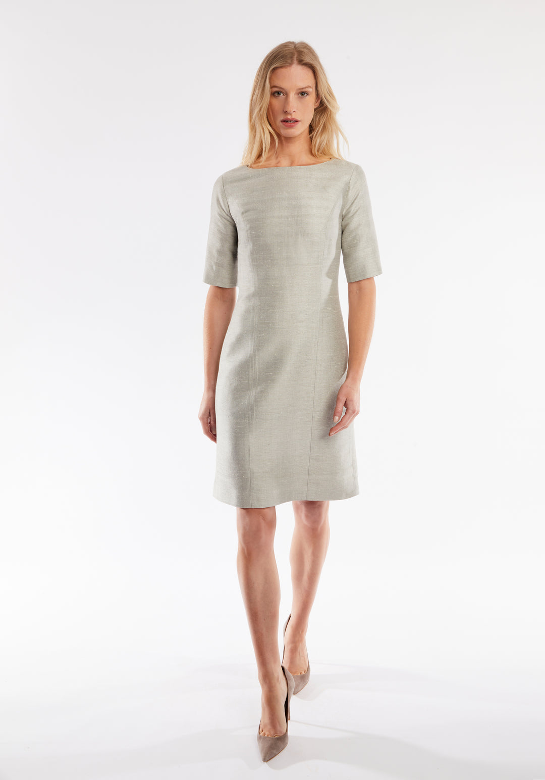 Woman wearing a light gray dress on a white background