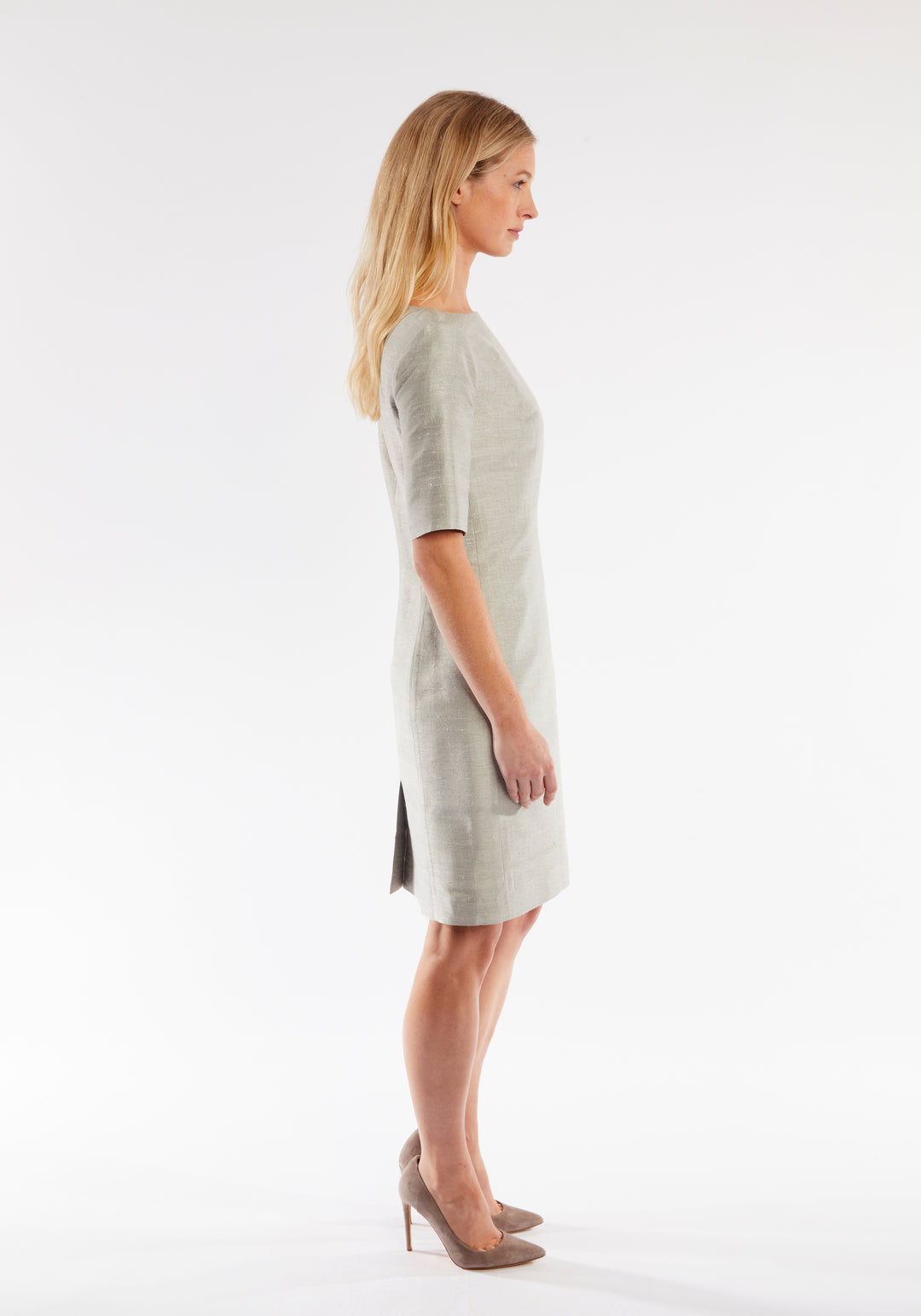 Woman wearing a light gray dress on a white background
