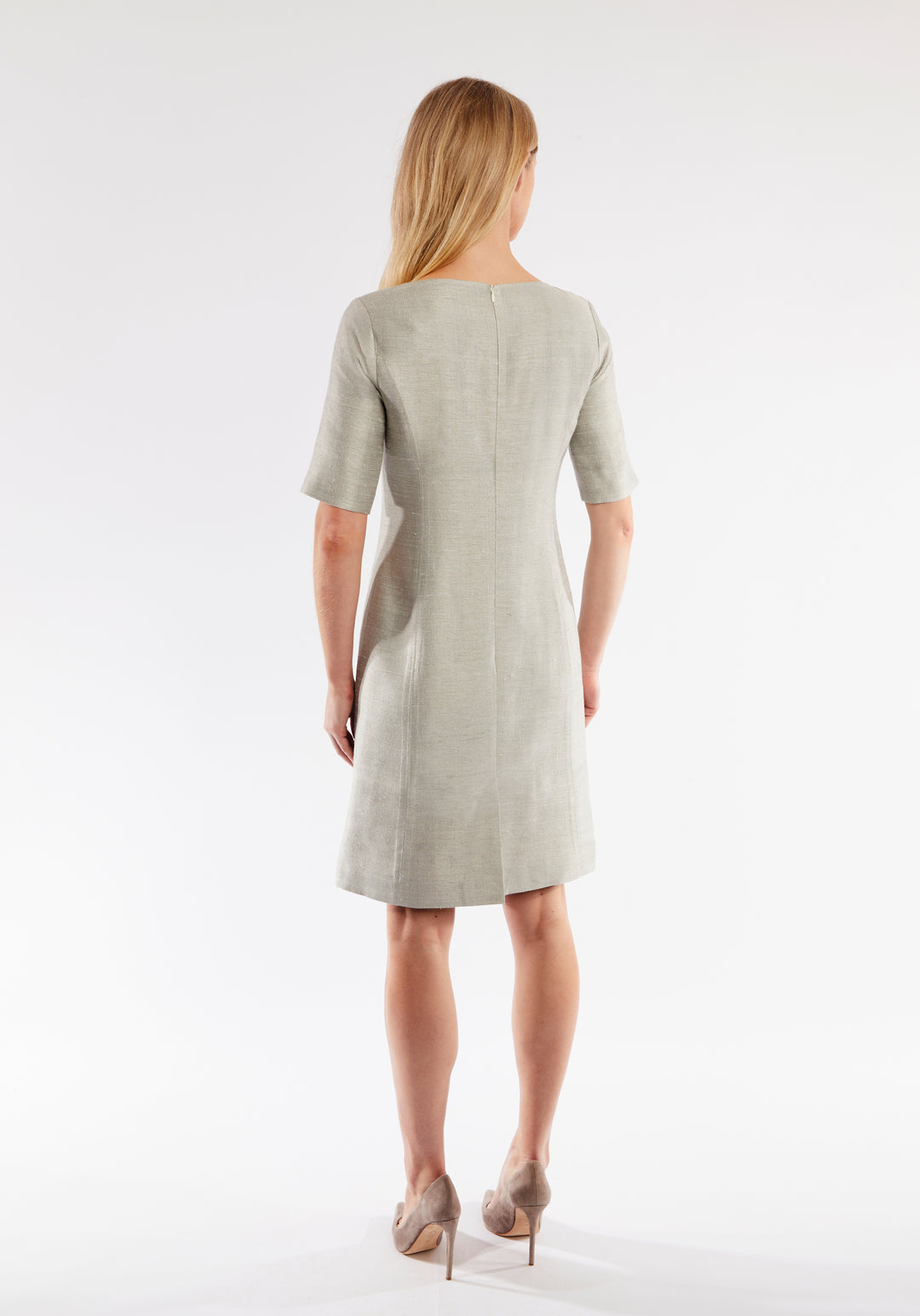 Woman wearing a light grey dress on a white background