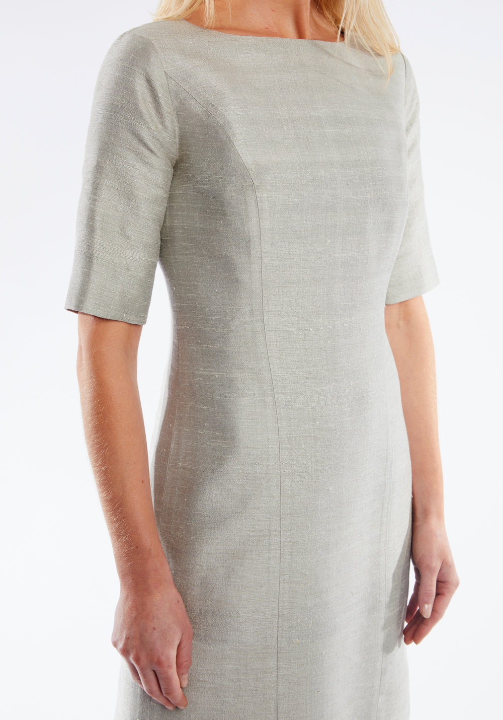 Woman wearing a light gray dress with short sleeves on a white background