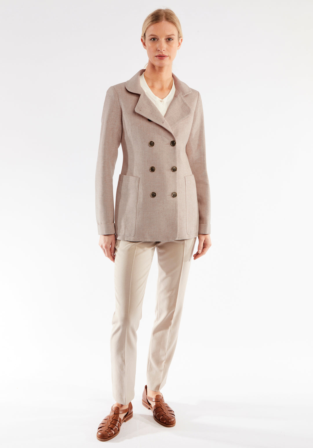 Woman wearing a pink jacket and pants on a white background