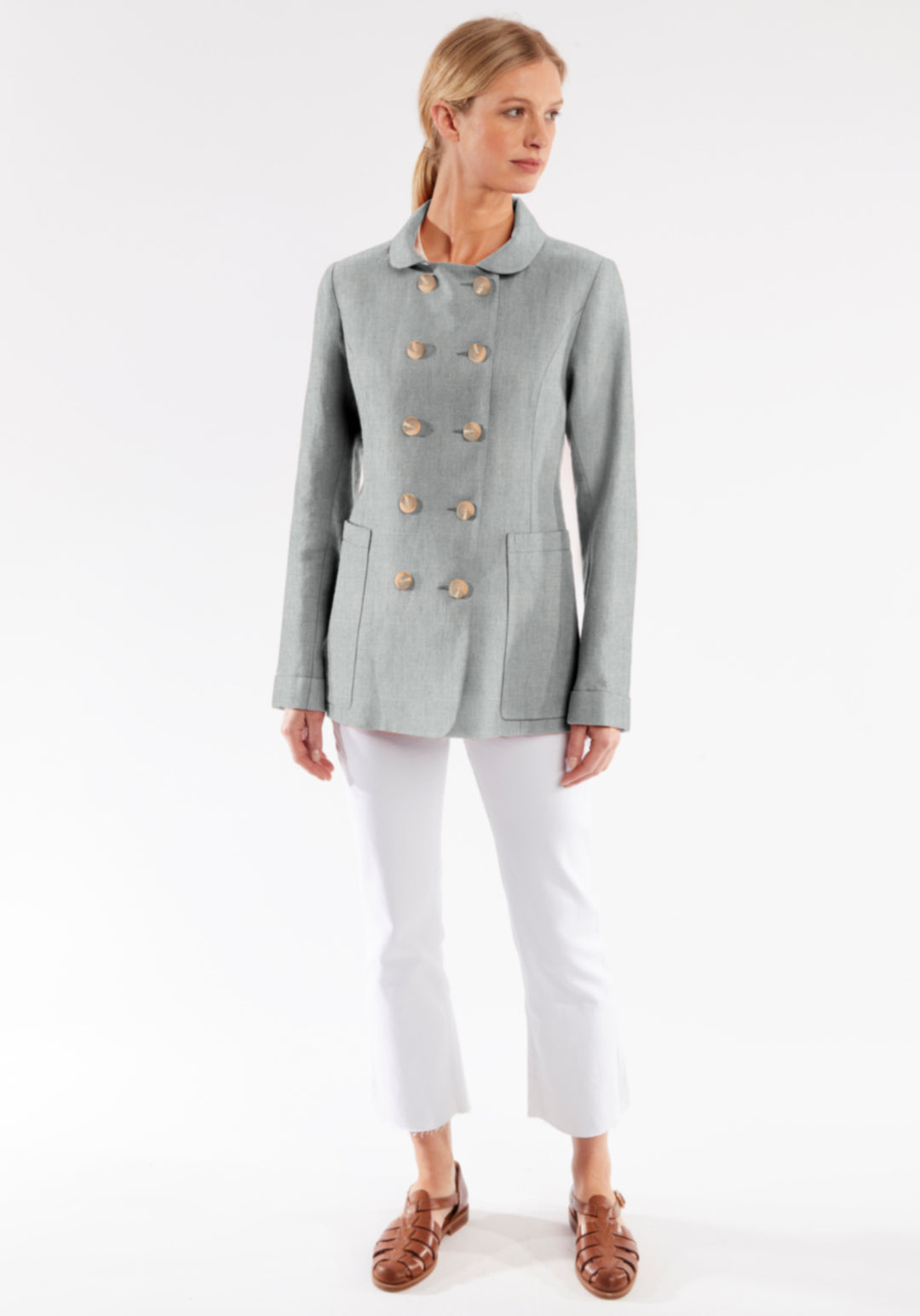Woman wearing a gray jacket with buttons on a white background