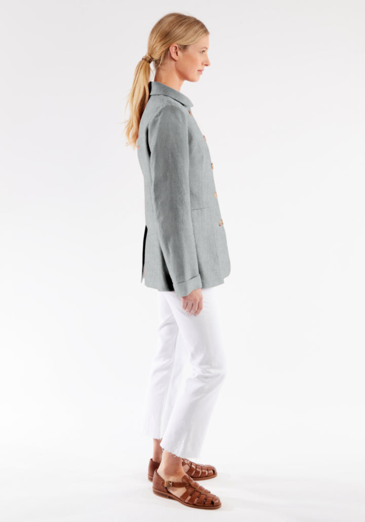 Woman wearing a gray jacket and white pants on a white background
