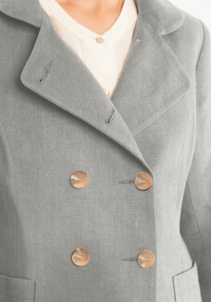 Close-up of a gray coat with buttons on a plain background