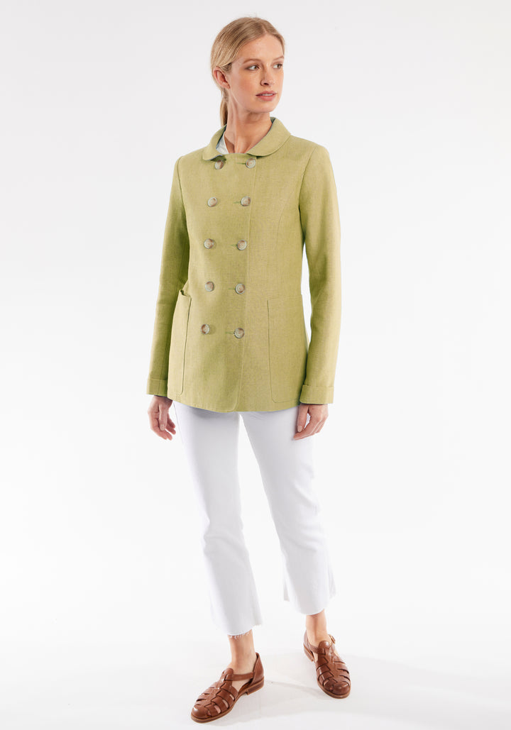 Woman wearing a light green jacket with button details on a white background