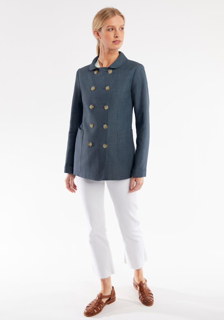Woman wearing a blue jacket with buttons on a white background
