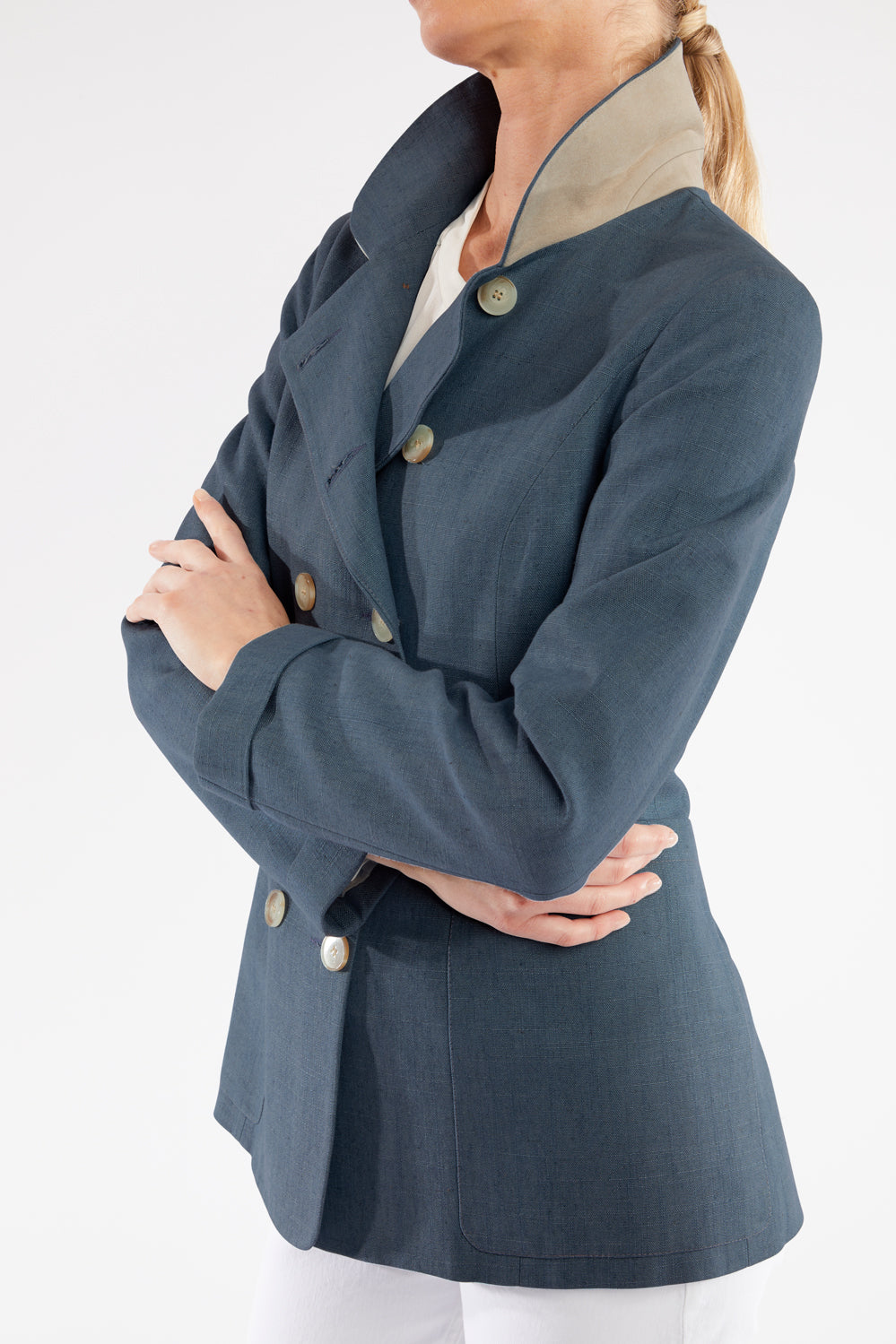 Woman wearing a blue jacket with buttons on a white background