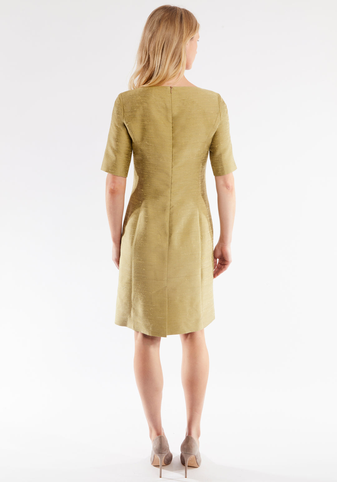 Woman wearing a cactus colored dress on a white background