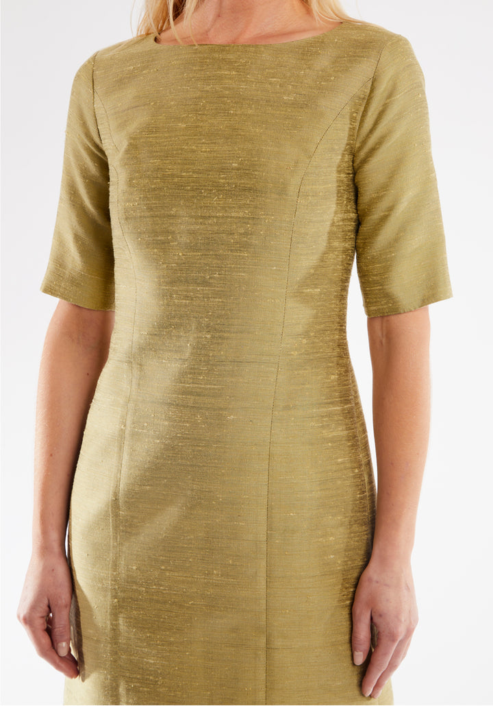 Woman wearing a cactus colored dress on a white background