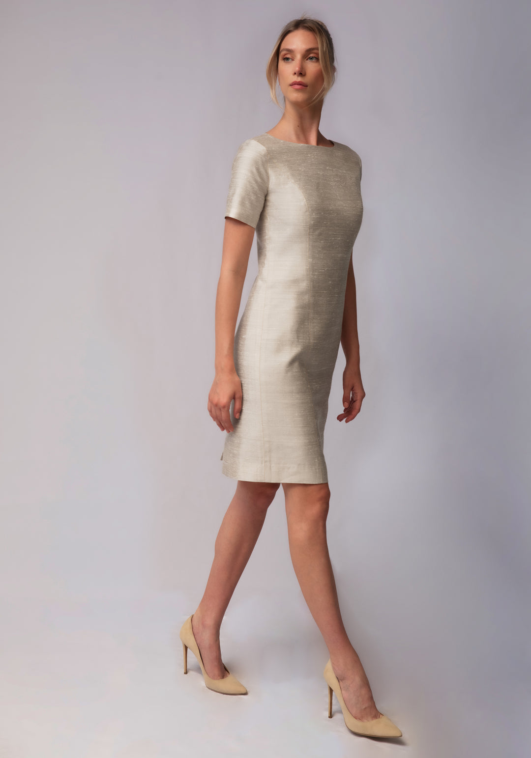 Woman wearing a light-colored dress against a plain background
