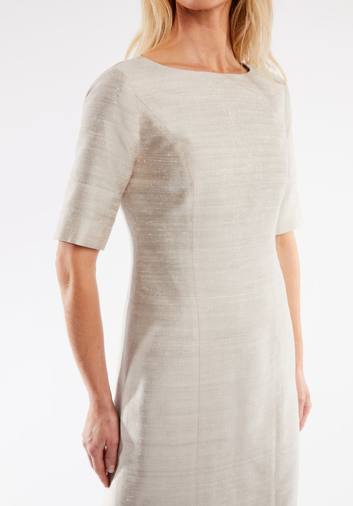 Woman wearing a light white dress against a white background