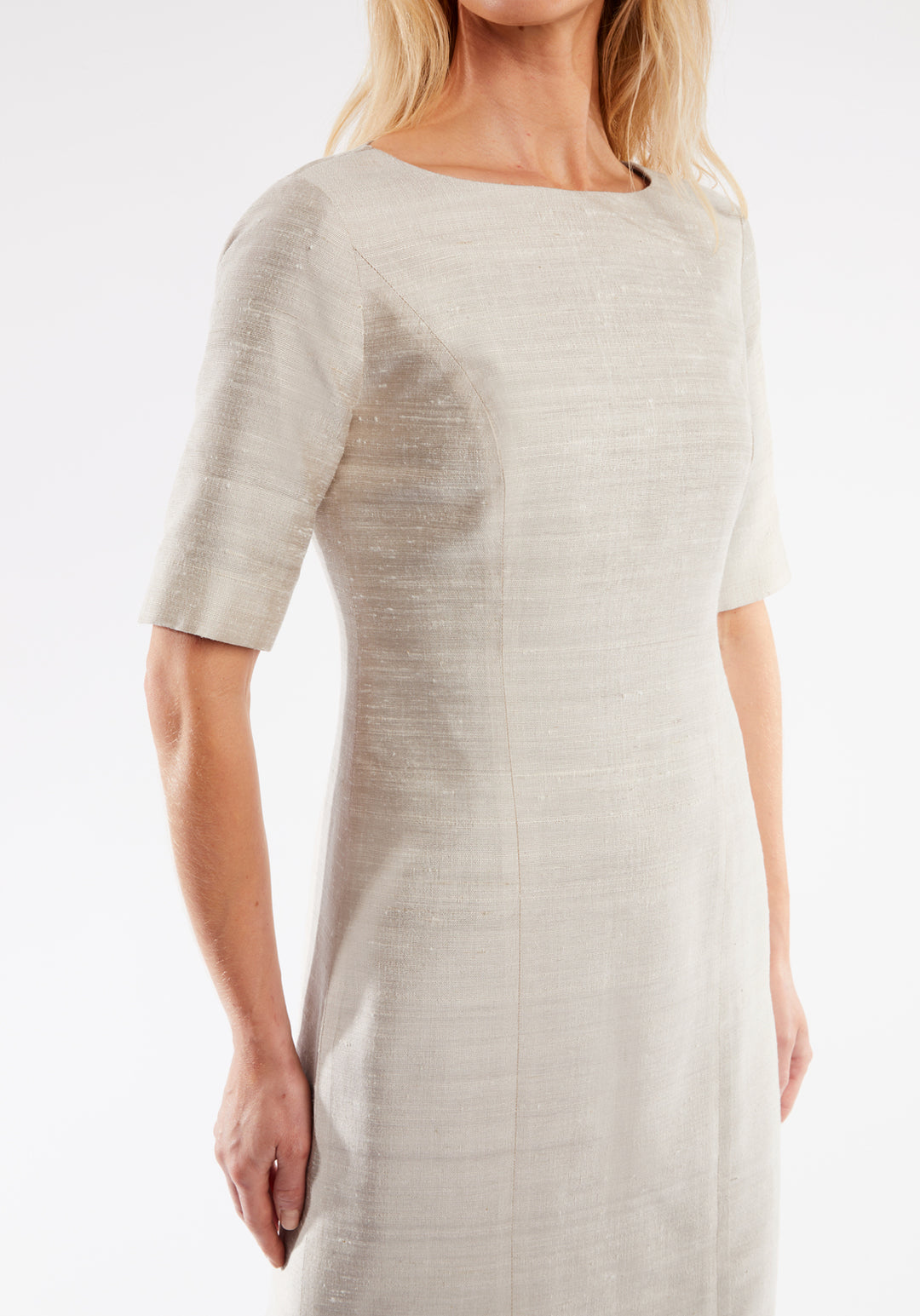 Woman wearing a light white dress against a white background