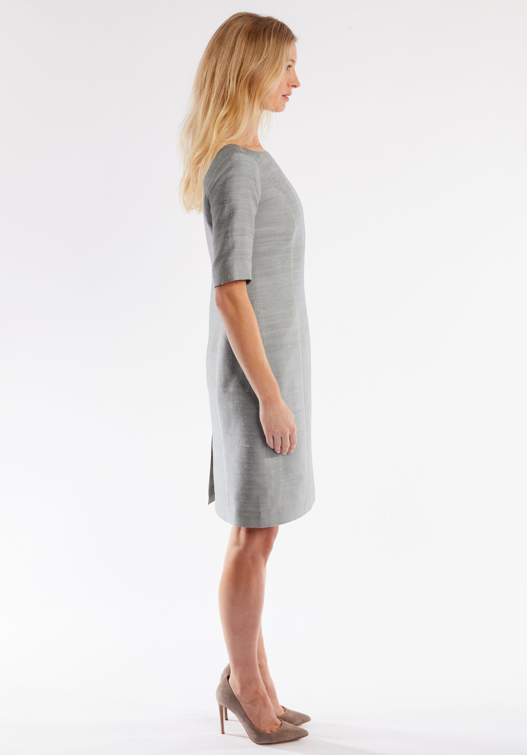 Woman wearing a gray dress on a white background