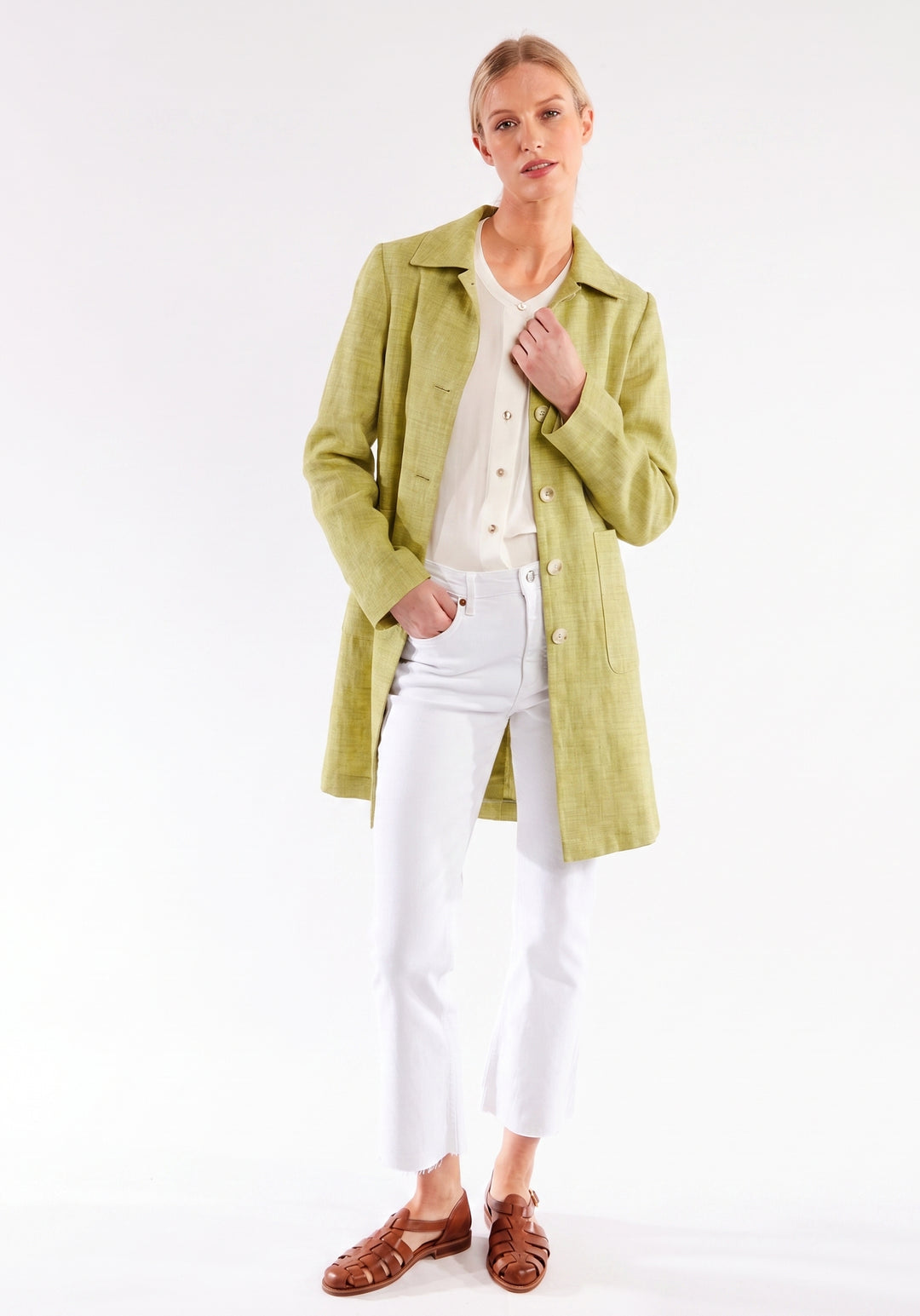 Woman wearing a chartreuse coat on a white background