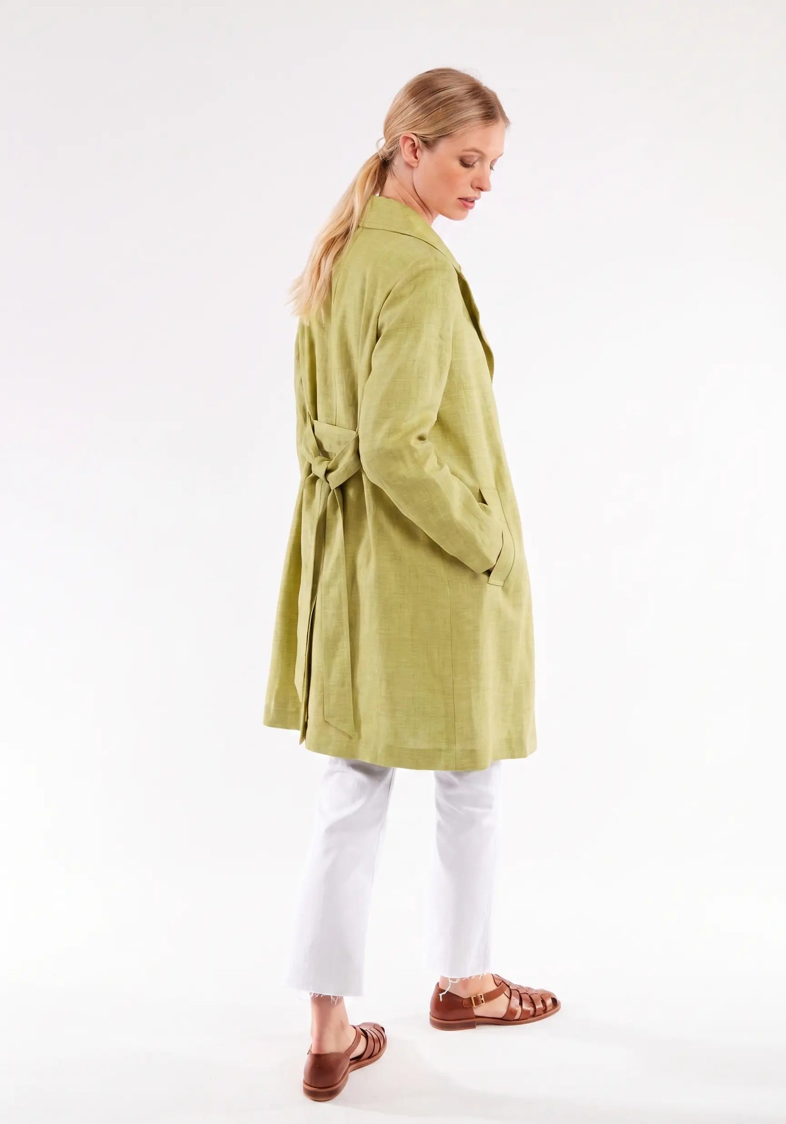 Woman wearing a green coat on a white background