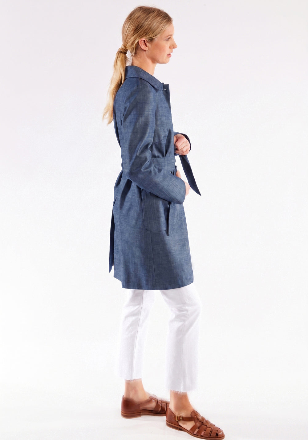 Woman wearing a blue coat with a white background
