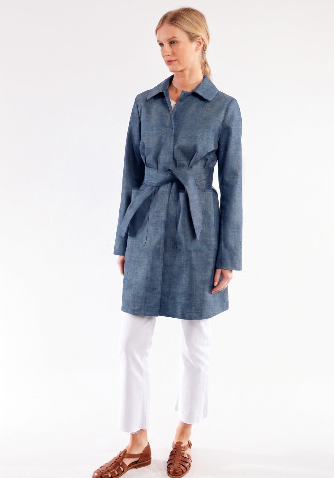 Woman wearing a blue coat with a white background