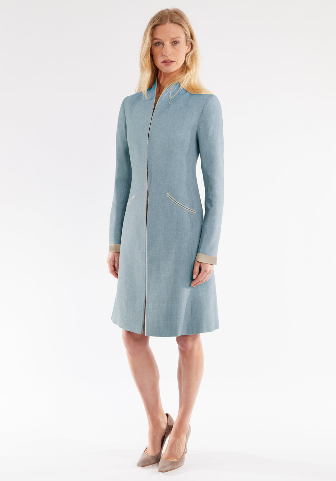 Woman wearing a light blue coat on a white background