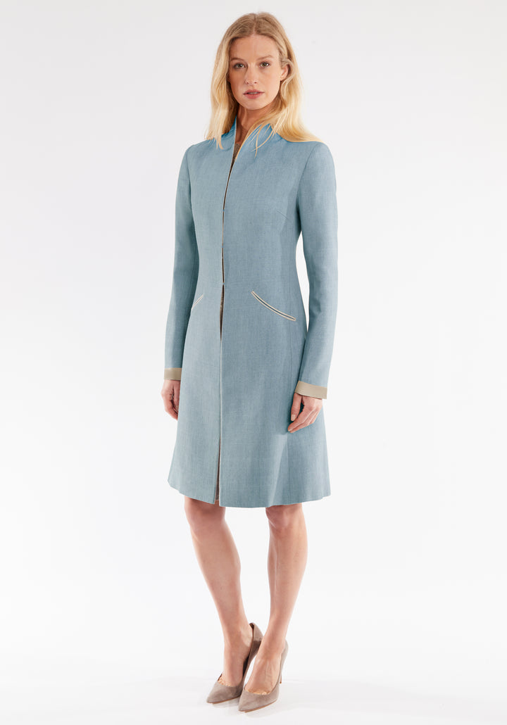 Woman wearing a light blue coat on a white background