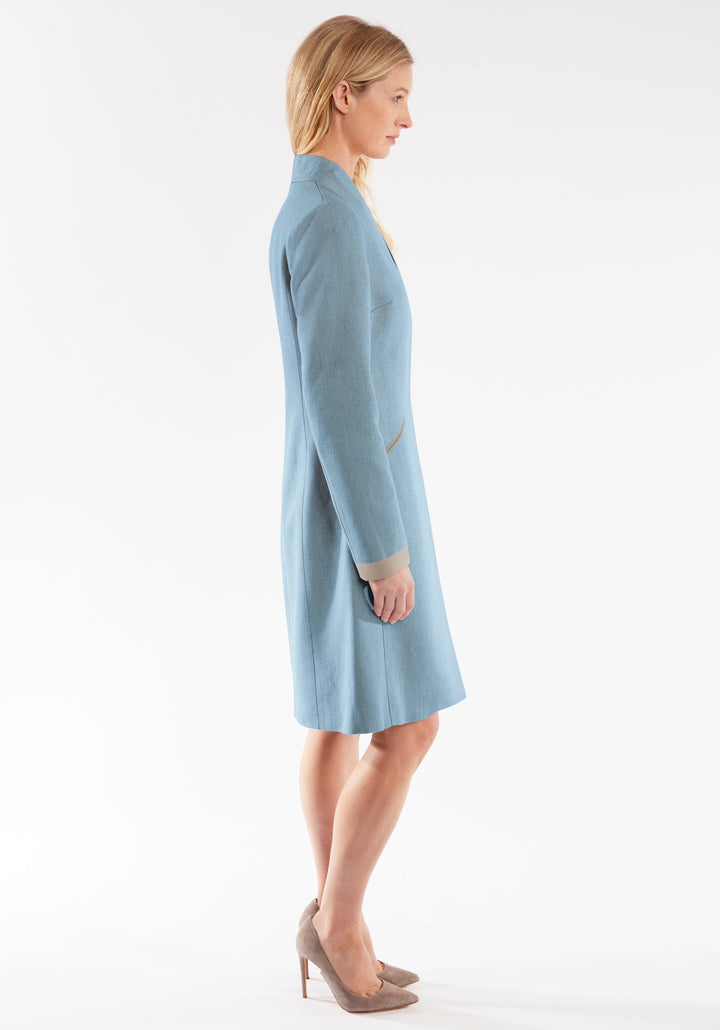 Woman wearing a light blue coat on a white background
