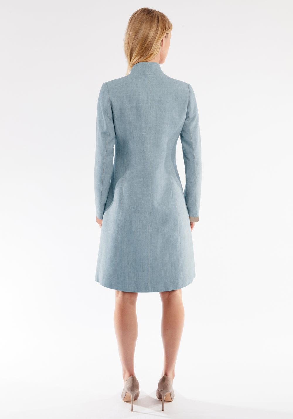 Woman wearing a light blue coat on a white background
