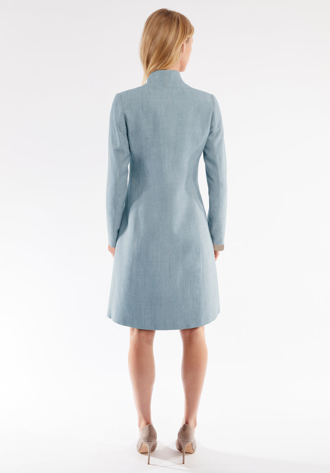 Woman wearing a light blue coat on a white background