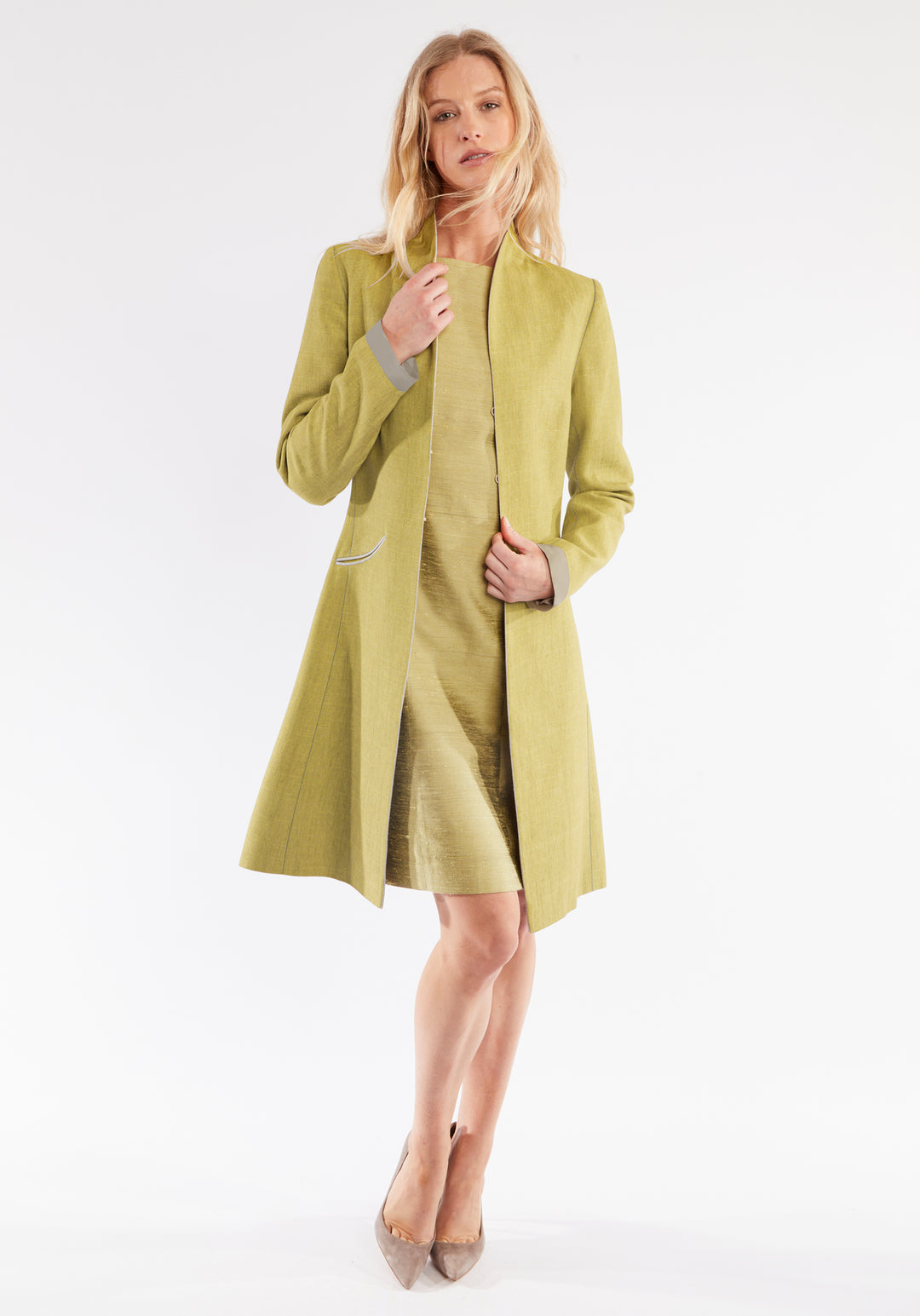 Woman wearing a chartreuse coat on a white background